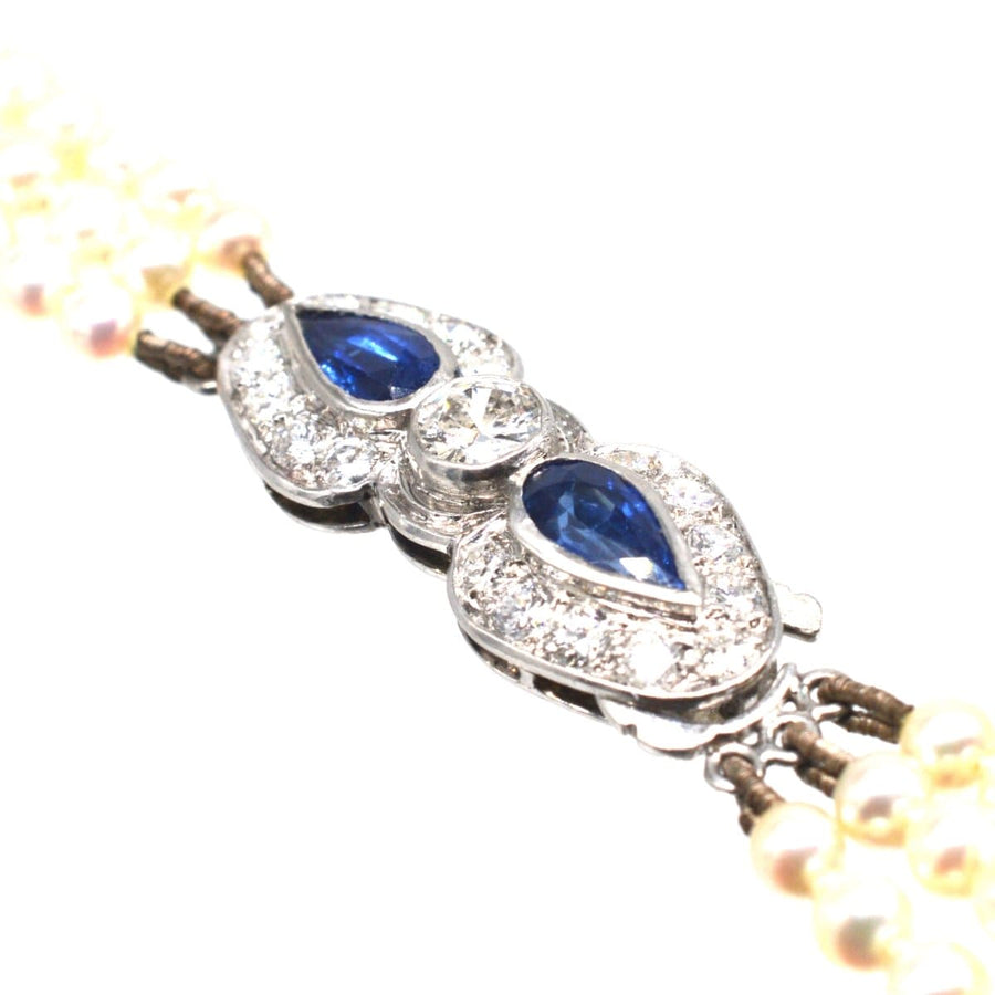 1940s triple strand cultured pearl necklace with sapphire & diamond clasp, featuring a stunning platinum design.