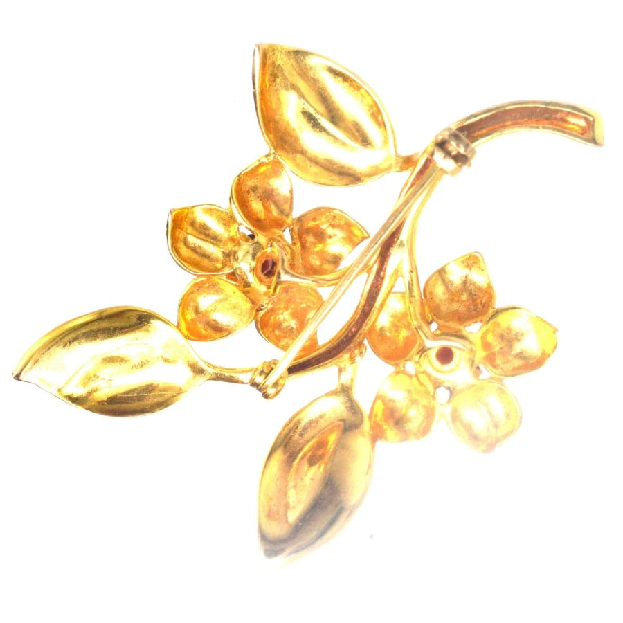 1960s 9ct gold and garnet floral spray brooch featuring gold leaves and garnet flowers, perfect for dresses and jackets.