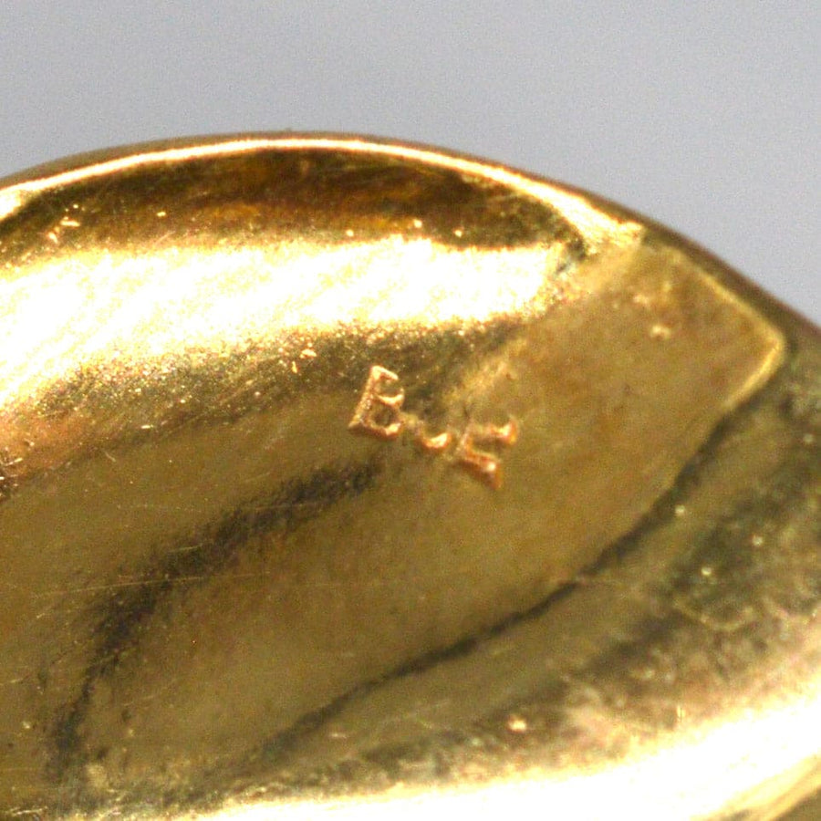 Close-up of the hallmark on a 1960s 9ct gold floral spray brooch, showcasing quality craftsmanship.