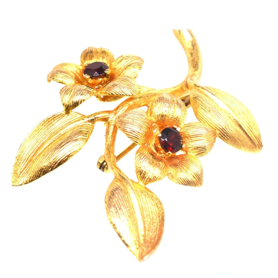 1960s 9ct gold and garnet floral spray brooch featuring intricate flower and leaf designs.