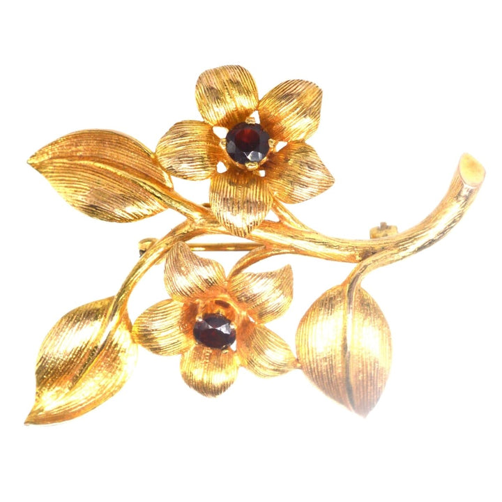 1960s 9ct gold and garnet floral spray brooch, featuring detailed flowers and leaves, perfect for dresses or jackets.
