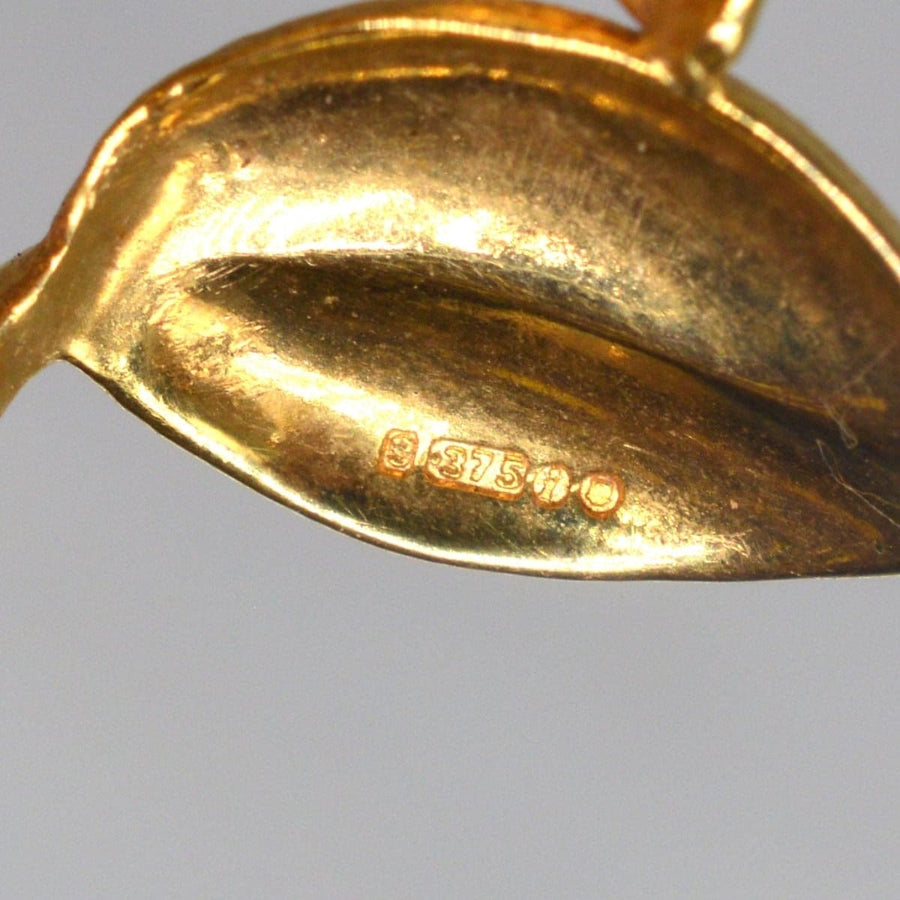 Close-up of the hallmark on a 1960s 9ct gold floral spray brooch, showing 375 mark for gold quality.