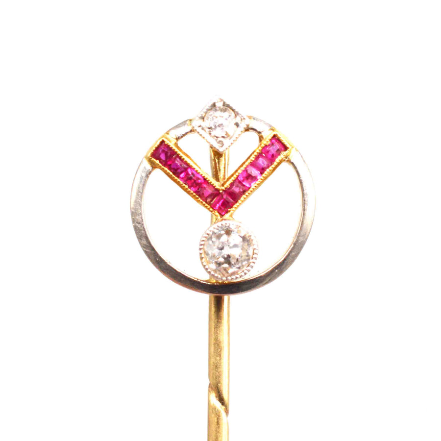 Art Deco gold pin featuring geometric design with rubies and diamonds, showcasing vintage elegance.