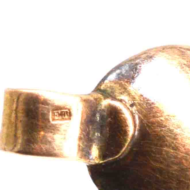 Close-up of a gold cross pendant showing hallmark and polished surface from the early Georgian era.
