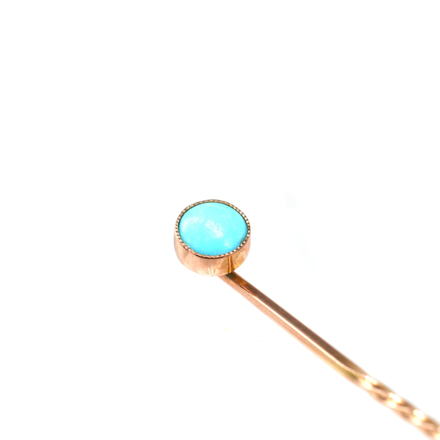 Edwardian 9ct gold tie pin featuring a vibrant turquoise stone in a classic millegrain setting.