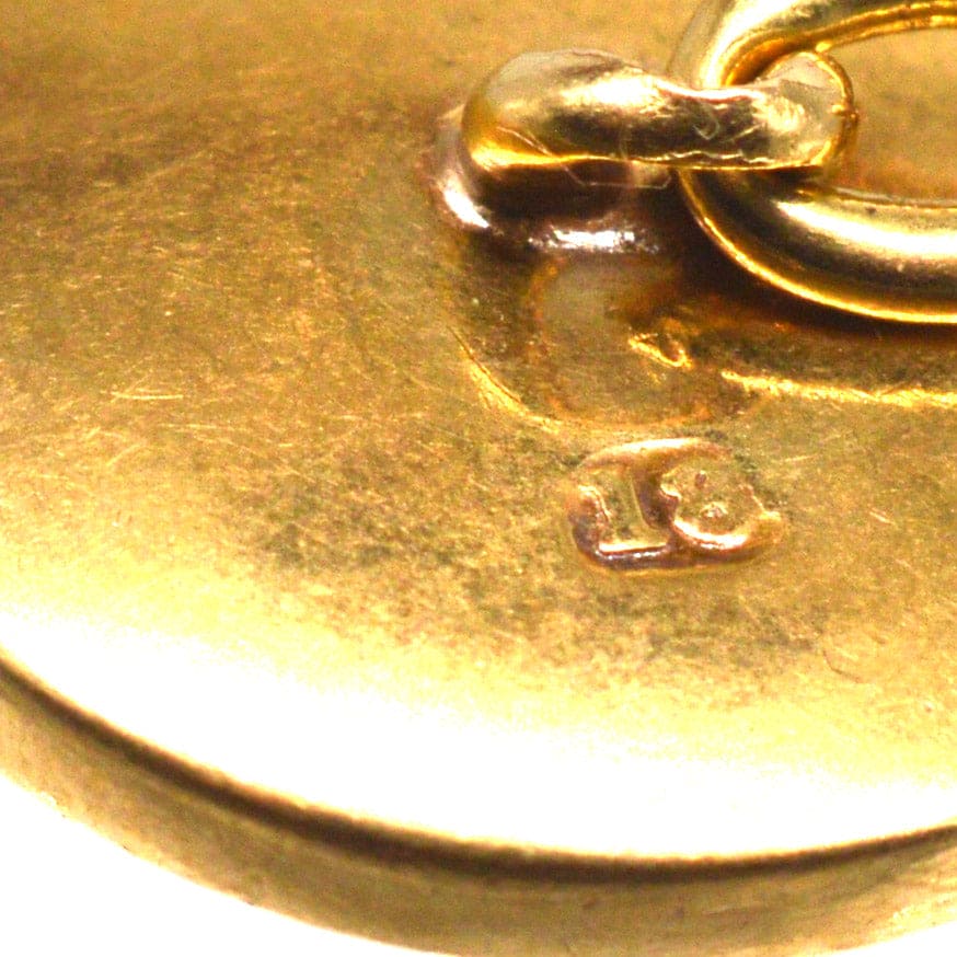 Close-up of the hallmark on Edwardian 18ct gold cufflinks showcasing craftsmanship and quality.