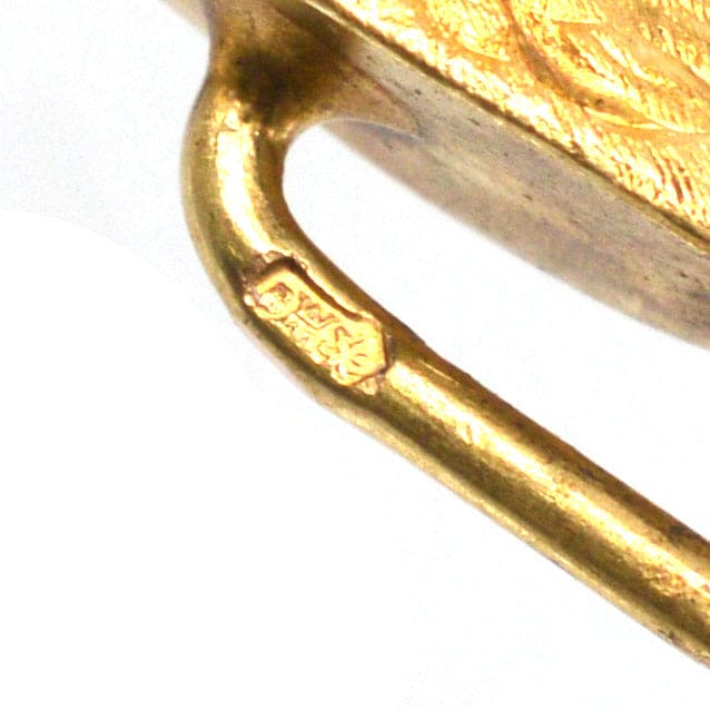 Detailed view of the hallmark on a 14ct gold tie pin with intricate design.