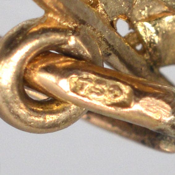 Close-up of vintage 9ct gold Vikings ship charm showing hallmark for authenticity and quality.