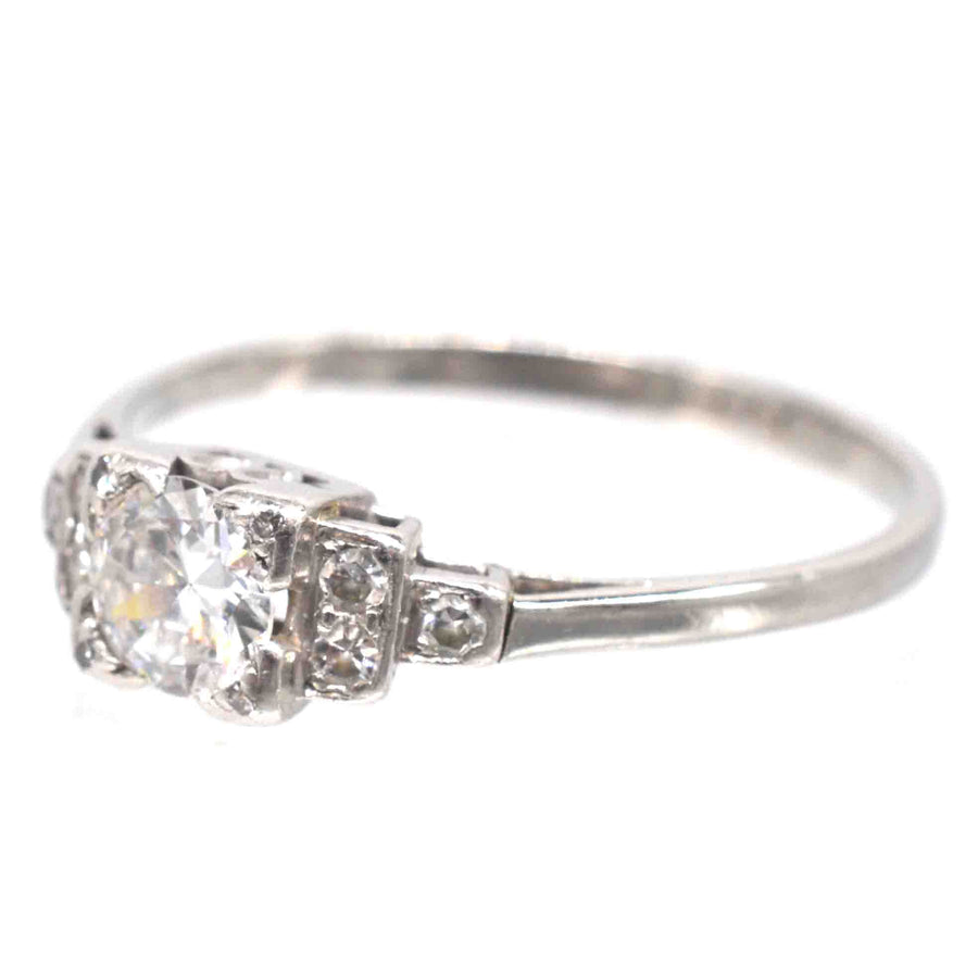 Art Deco platinum diamond solitaire ring, featuring a 0.30-carat Old Transitional Cut diamond and step-like diamond shoulders.