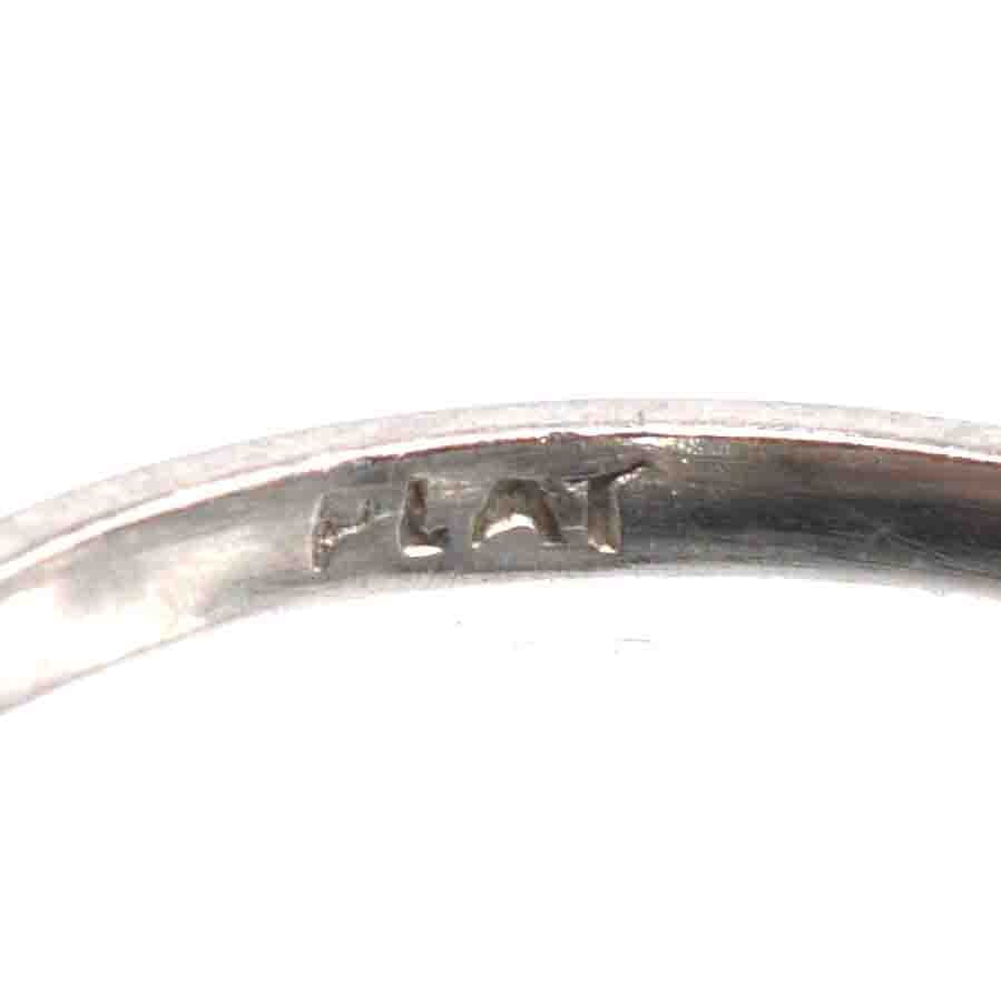 Close-up of the inside engraving on an Art Deco platinum ring showing the word 'PLAT'.