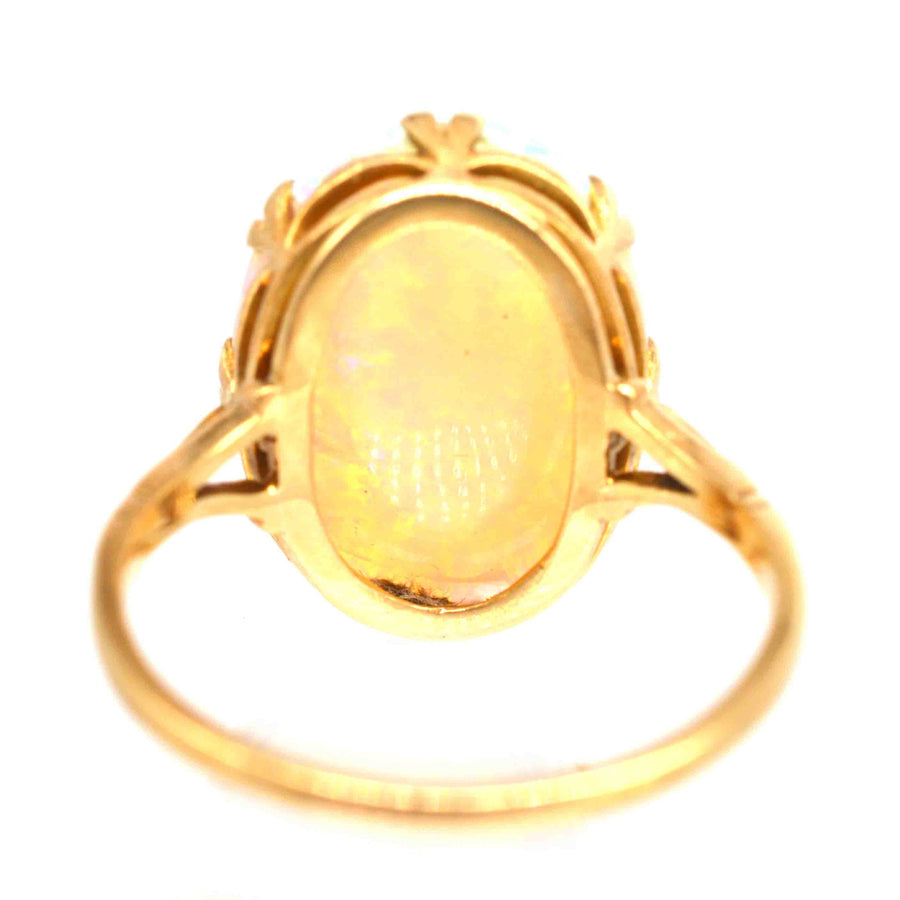 Edwardian 18ct gold ring featuring a large, lustrous opal with shifting colors of green and blue.