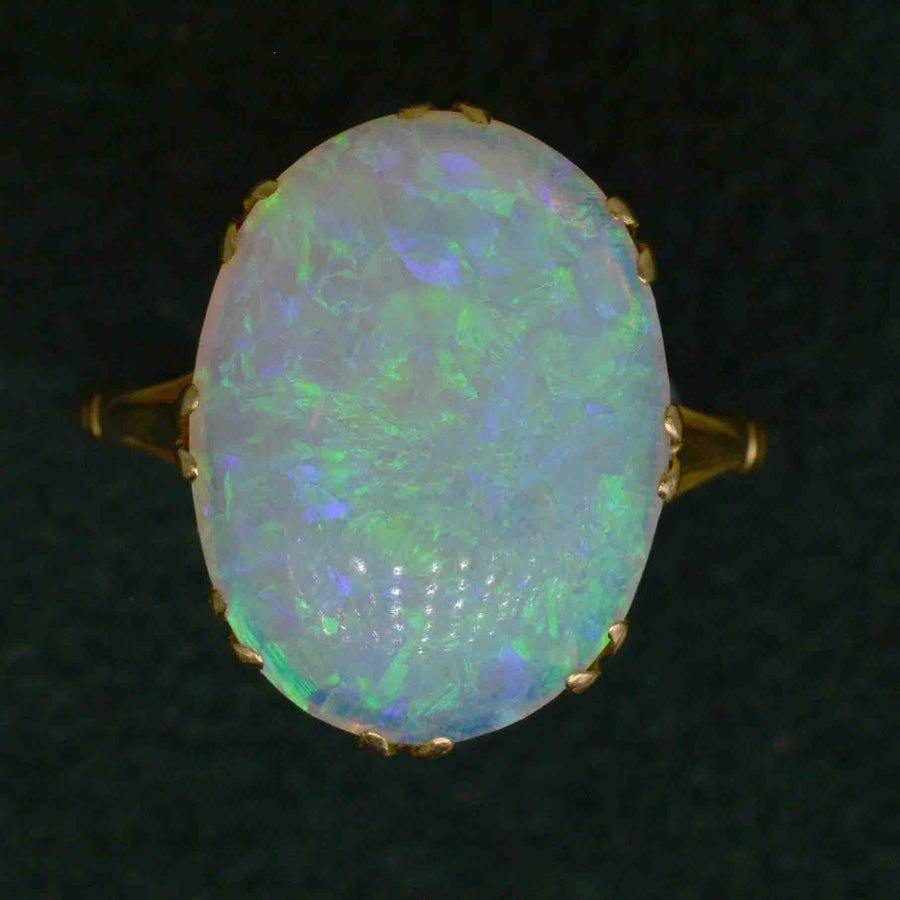 Edwardian 18ct gold ring featuring a large opal with vibrant green and blue flashes.