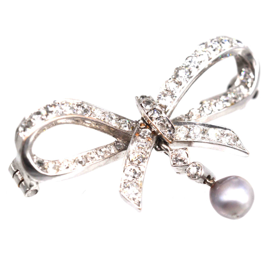Early 20th century 14ct white gold diamond bow brooch with grey pearl detail.