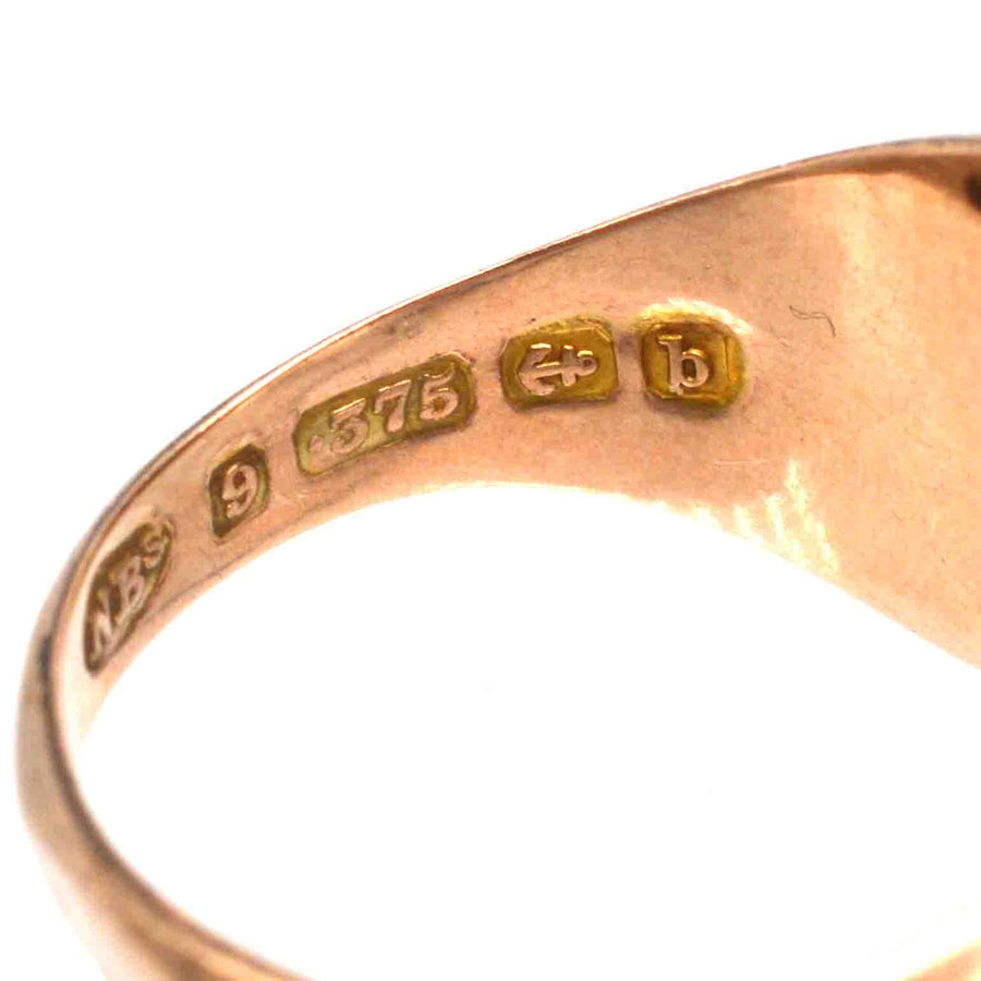 Close-up of the inner band of an Edwardian 9ct gold signet ring showing hallmark and assay marks.