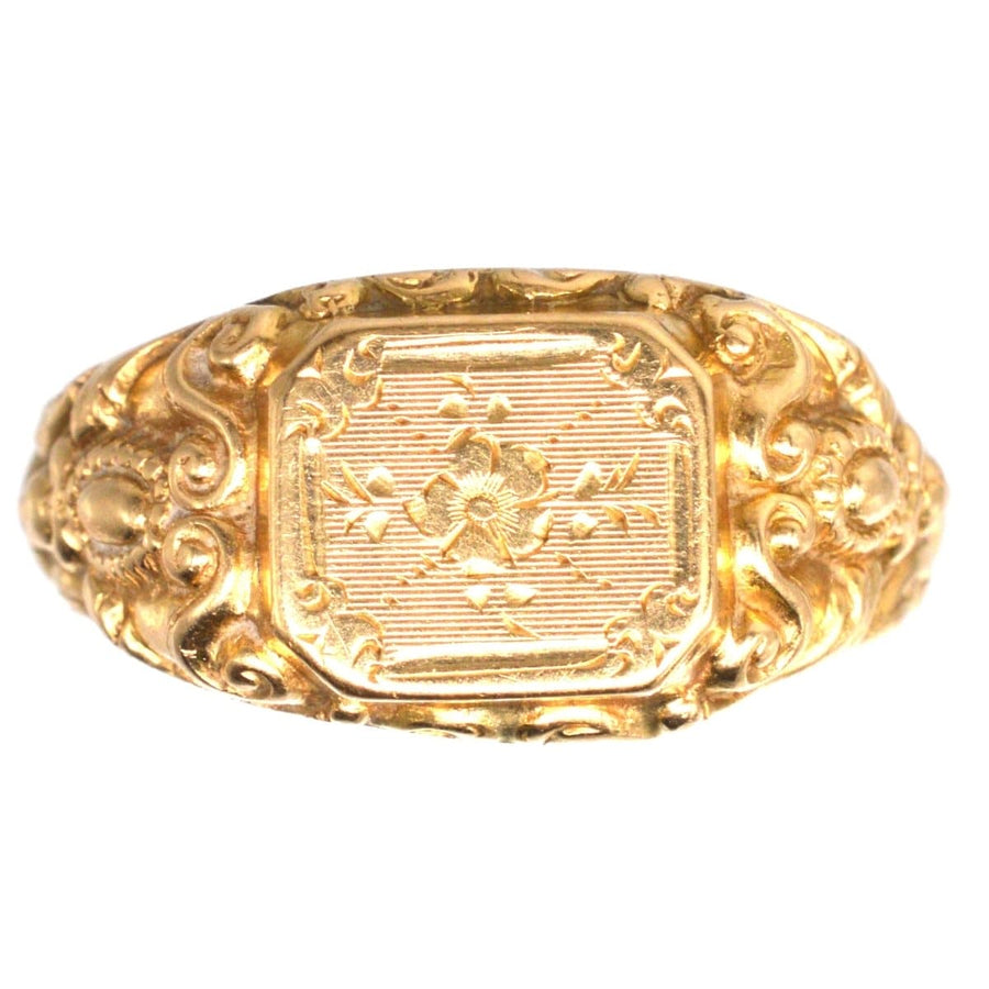 Antique French 18ct gold ring featuring intricate rose engravings and decorative swirls on a buttery gold surface.