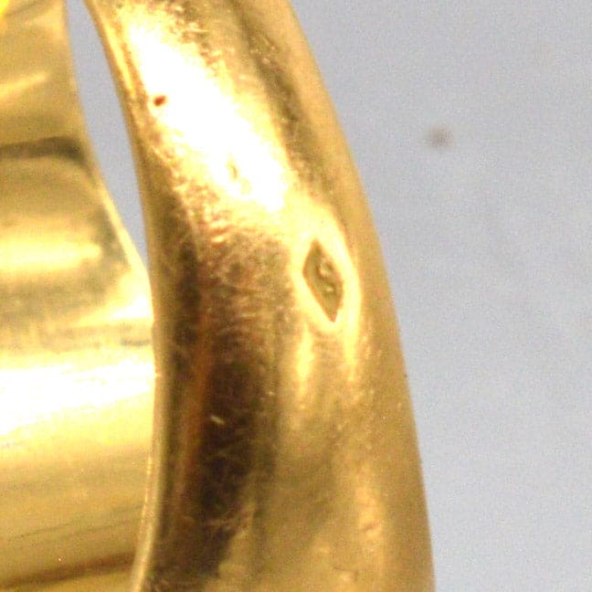 Close-up of the antique French 18ct gold signet ring showcasing the detailed engraving and buttery gold finish.