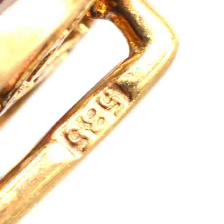 Close-up of 14ct gold hallmark on Art Deco geometric pin, showcasing craftsmanship and authenticity.
