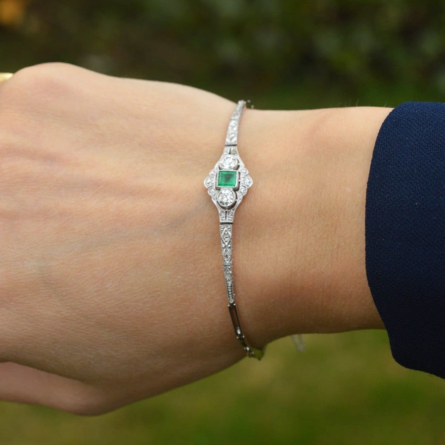 Art Deco 14ct white gold bracelet featuring a square-cut emerald and two diamonds on a wrist.