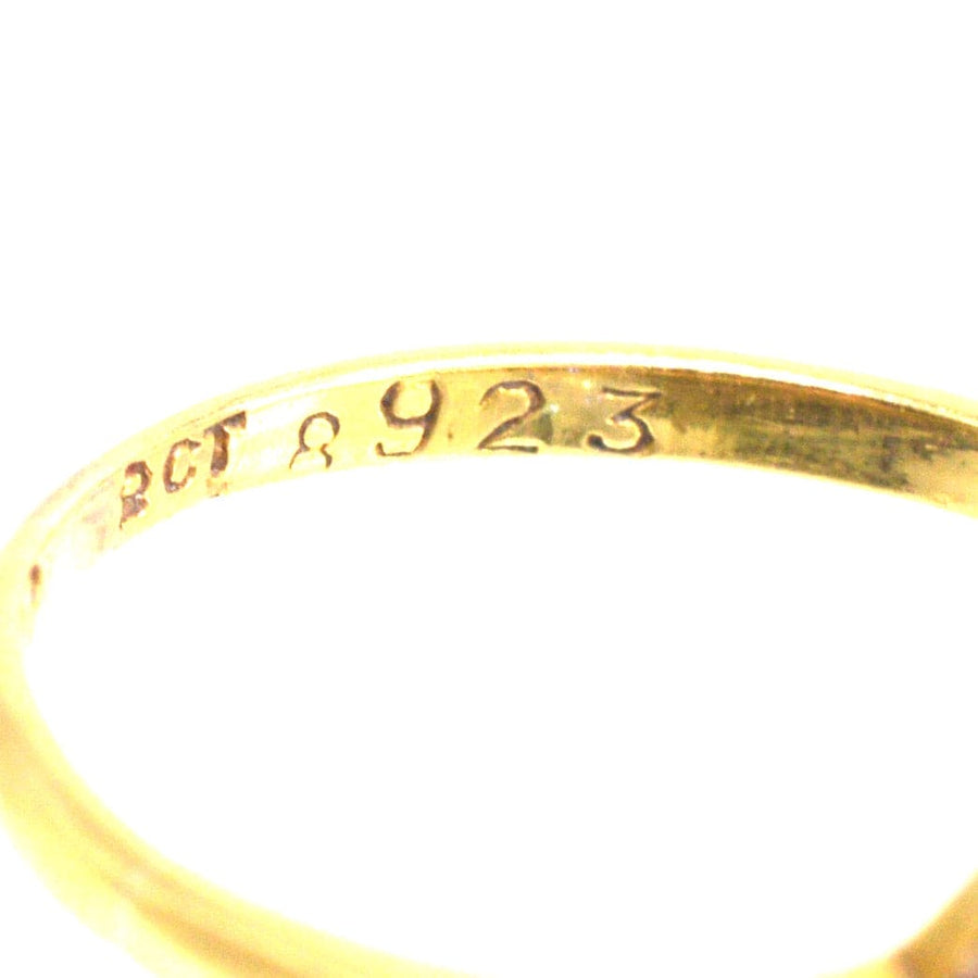 Close-up of the inner engraving on a gold ring, displaying 'BCT 8923' hallmark.