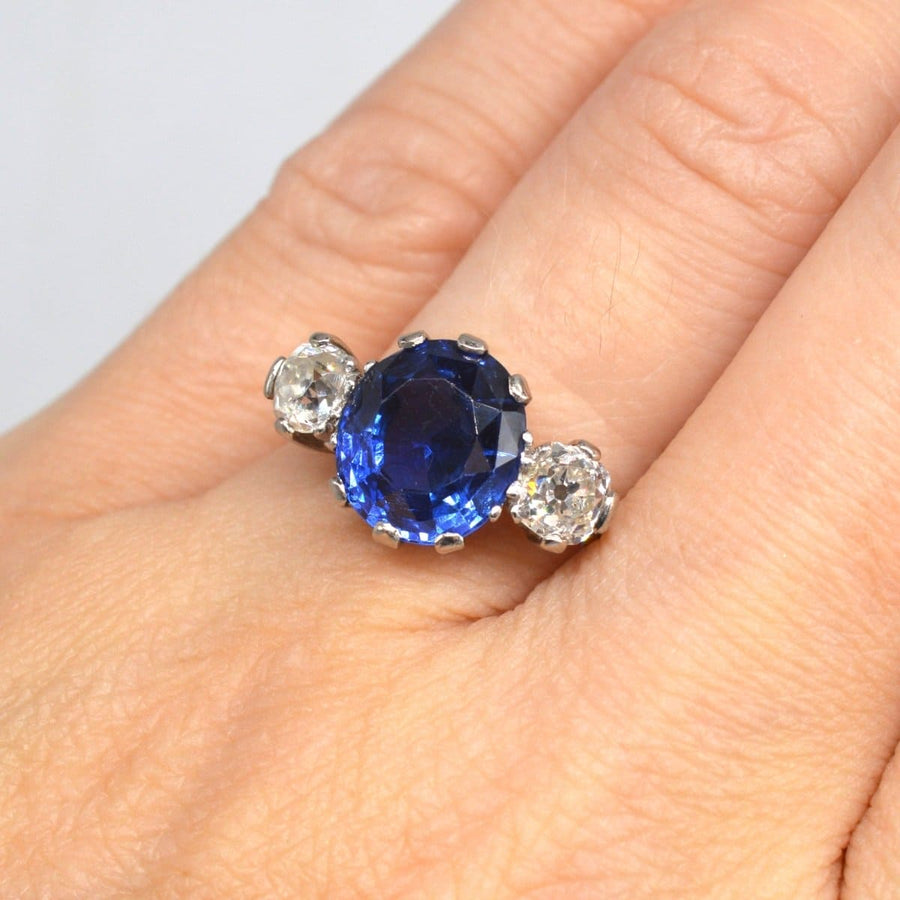 Art Deco 18ct gold ring featuring a 5.25 carat Ceylon sapphire and two side diamonds, showcasing exceptional craftsmanship.