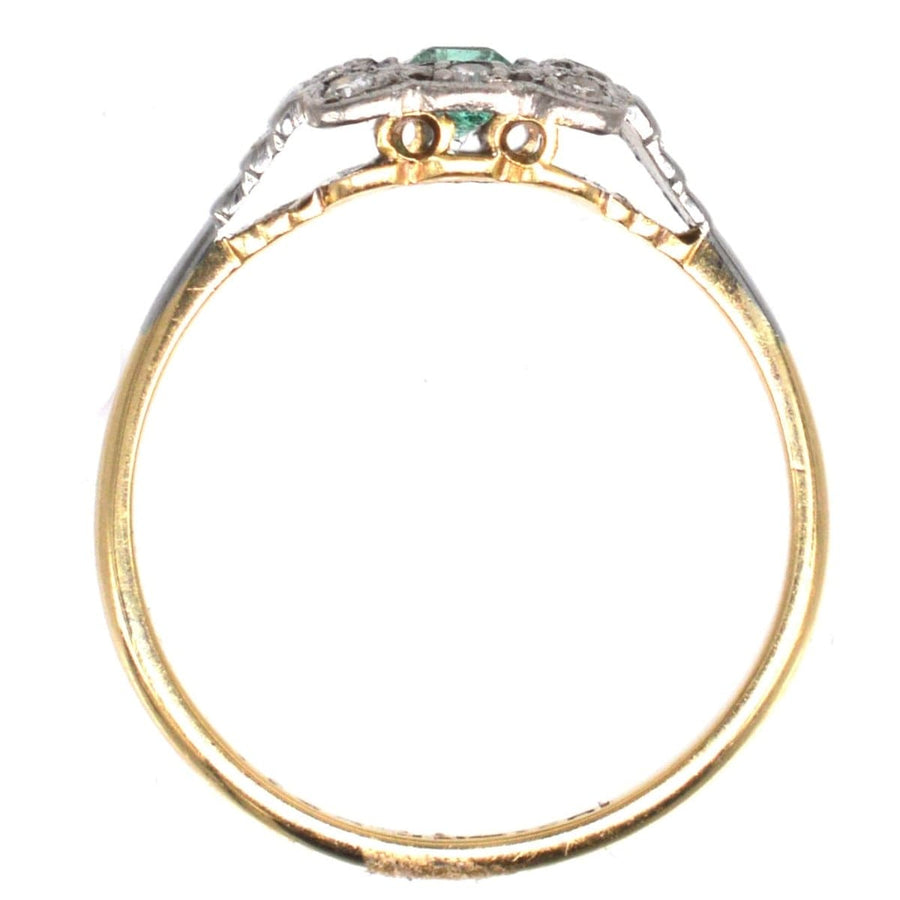 Art Deco 18ct gold and platinum ring featuring an emerald center stone and diamond accents in a millegrain setting.