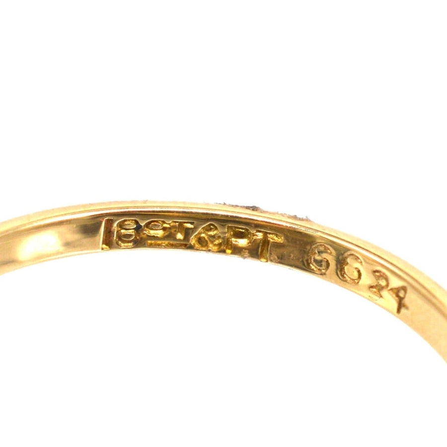 Close-up of the inner band of an 18ct gold and platinum ring, featuring hallmark engraving.