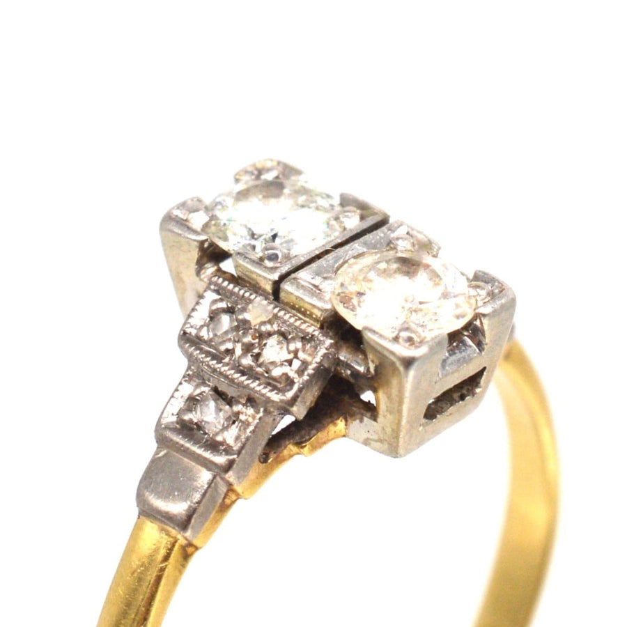 Art Deco 18ct gold and platinum two stone diamond ring with intricate design and smaller diamonds on shoulders.