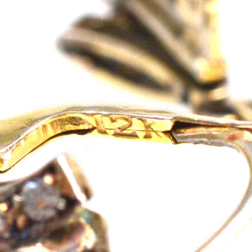 Close-up of 18ct gold hallmark on Art Deco emerald and diamond drop earrings, showcasing quality craftsmanship.