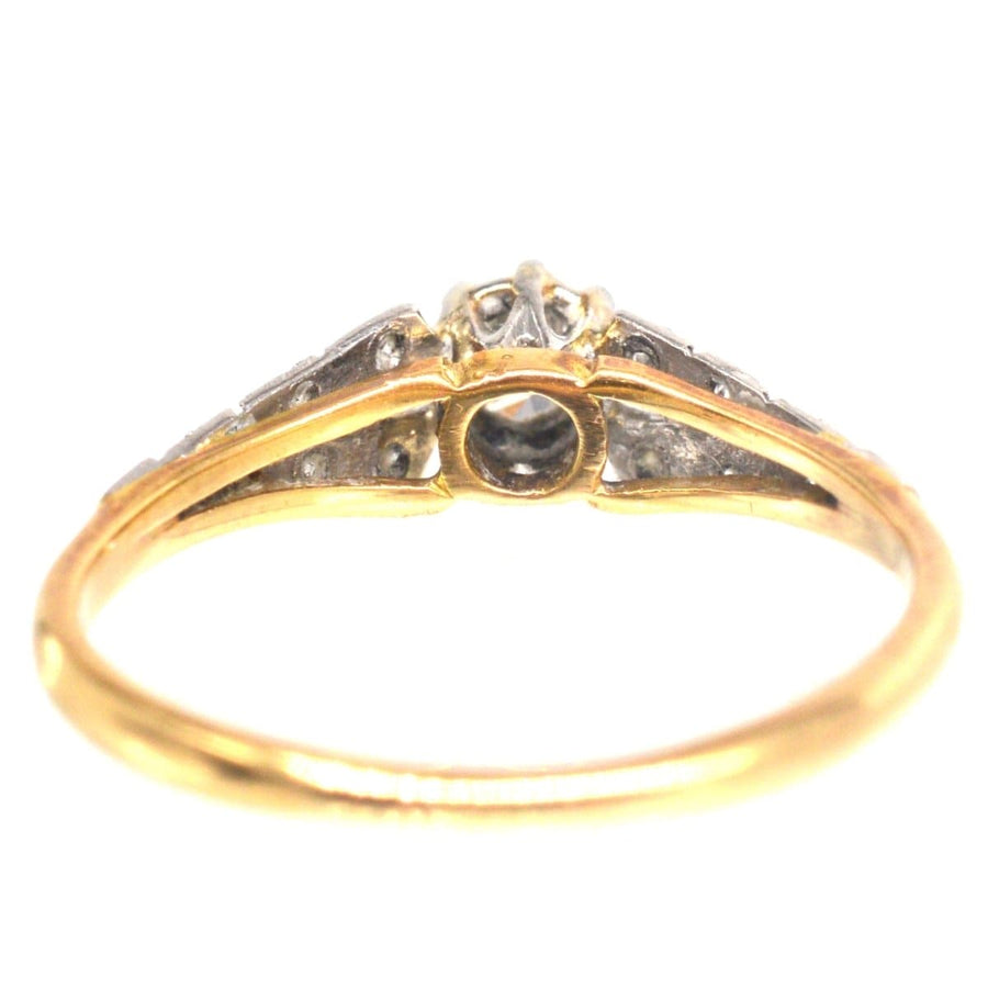 Art Deco 18ct gold and platinum diamond solitaire ring with diamond shoulders, showcasing exquisite craftsmanship.