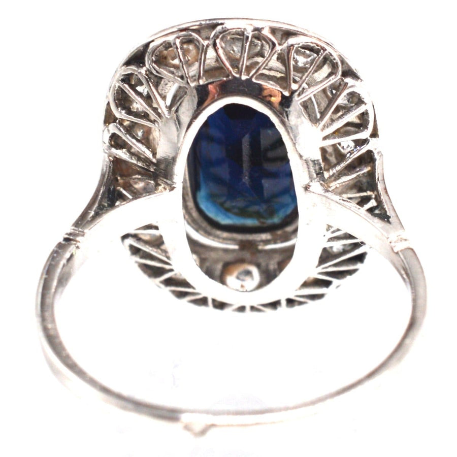 View of the Art Deco French platinum ring featuring a dark sapphire and diamond cluster from below.