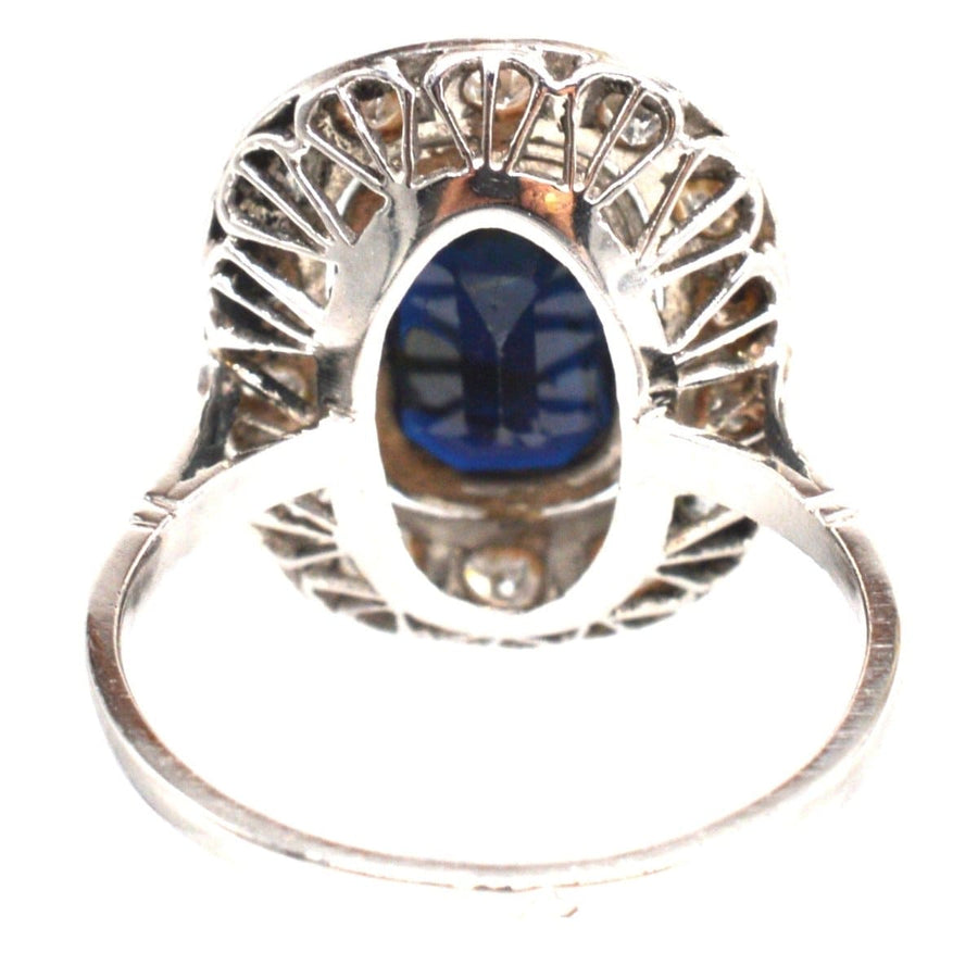 Art Deco platinum ring featuring a dark sapphire encircled by diamonds, showcasing exquisite craftsmanship.