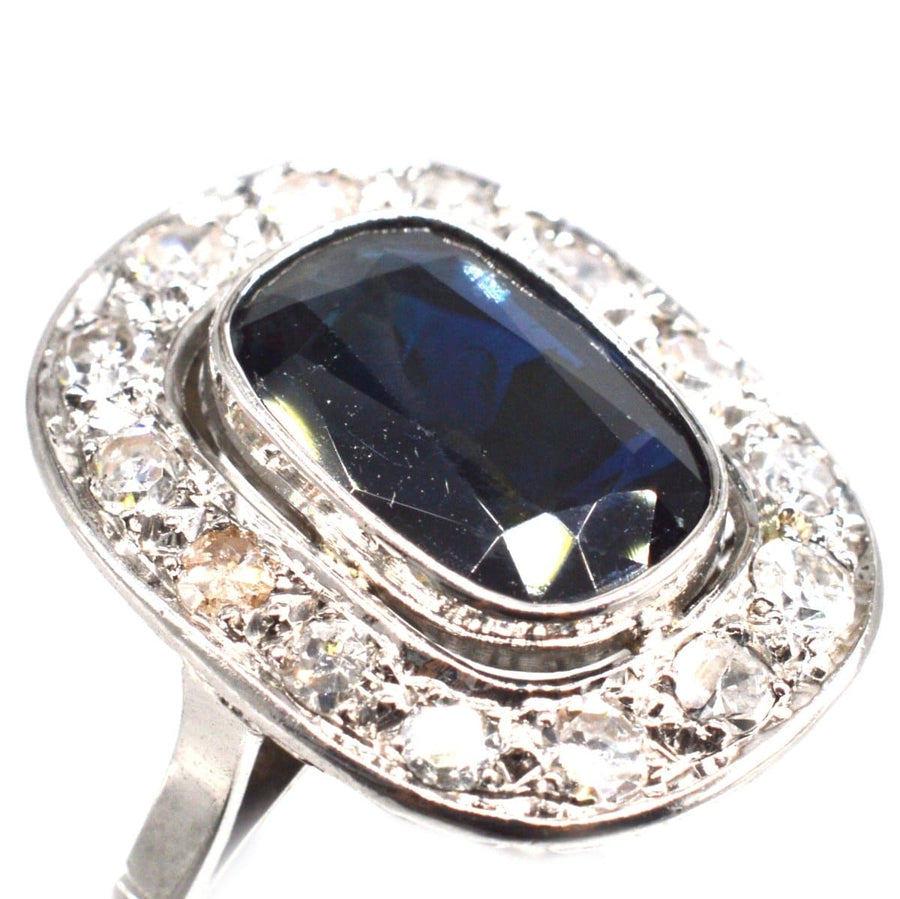 Art Deco French platinum ring featuring a dark sapphire surrounded by sparkling diamonds, perfect for an engagement.