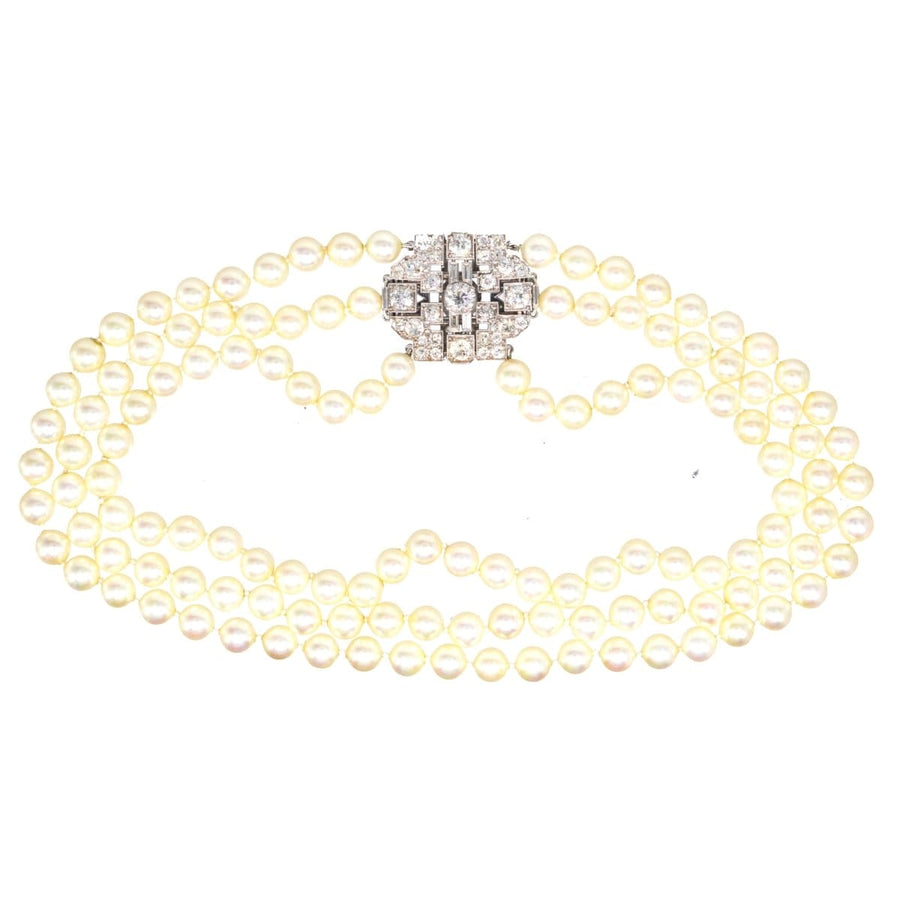 Art Deco 7 Carat Diamond brooch with pearl necklace attachment, elegantly showcased in a geometric design.