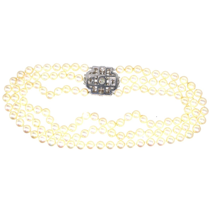 Art Deco platinum brooch with 7 carat diamond centerpiece and three-strand pearl necklace attachment.
