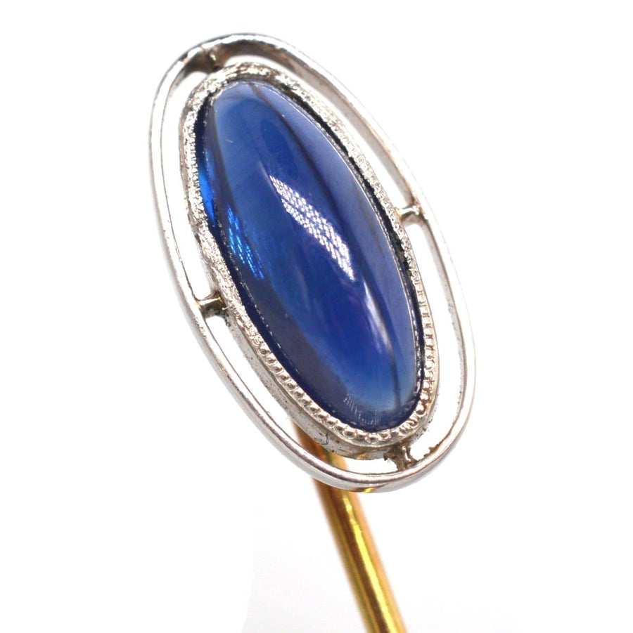 Art Deco platinum tie pin featuring a large sapphire in an open circular design, circa 1920s, perfect for a timeless gift.