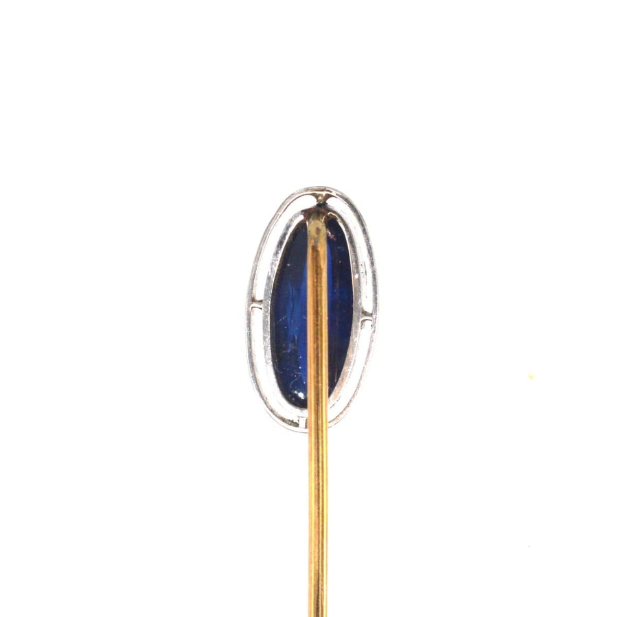 Art Deco platinum and sapphire tie pin featuring a sapphire in an open circular band, circa 1920s.
