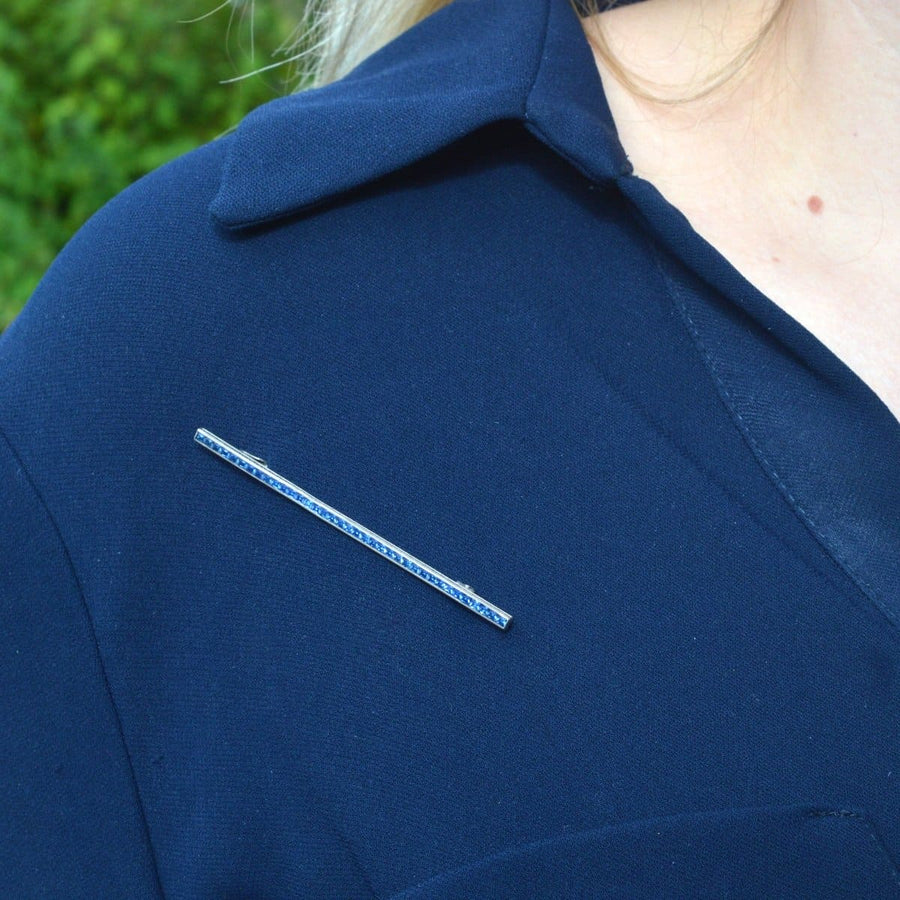 Art Deco silver blue paste bar brooch worn on a navy blue shirt, showcasing elegant design and vintage charm.