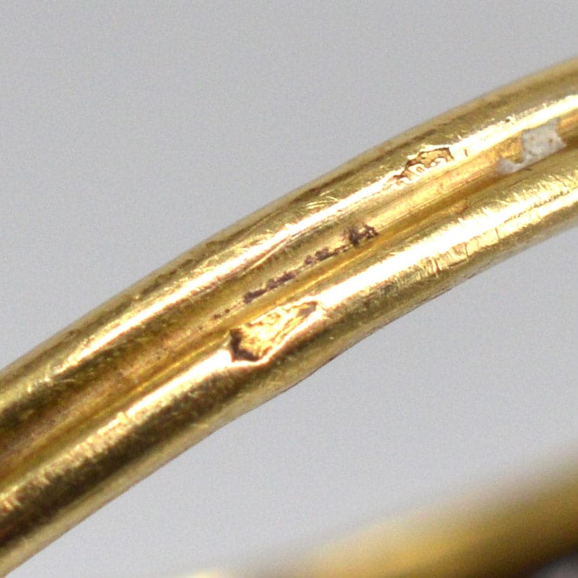 Close-up of the hallmarked gold band of an Art Nouveau vintage ring, showcasing fine details and craftsmanship.
