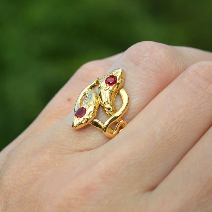 Antique French 18ct gold double snake ring with ruby and garnet, symbolizing eternal love and commitment.