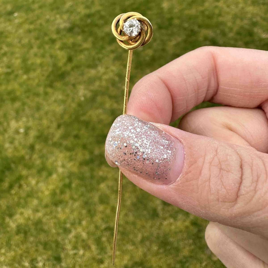 Early 20th century 14ct gold knot tie pin with diamond, symbolizing strength and eternity.
