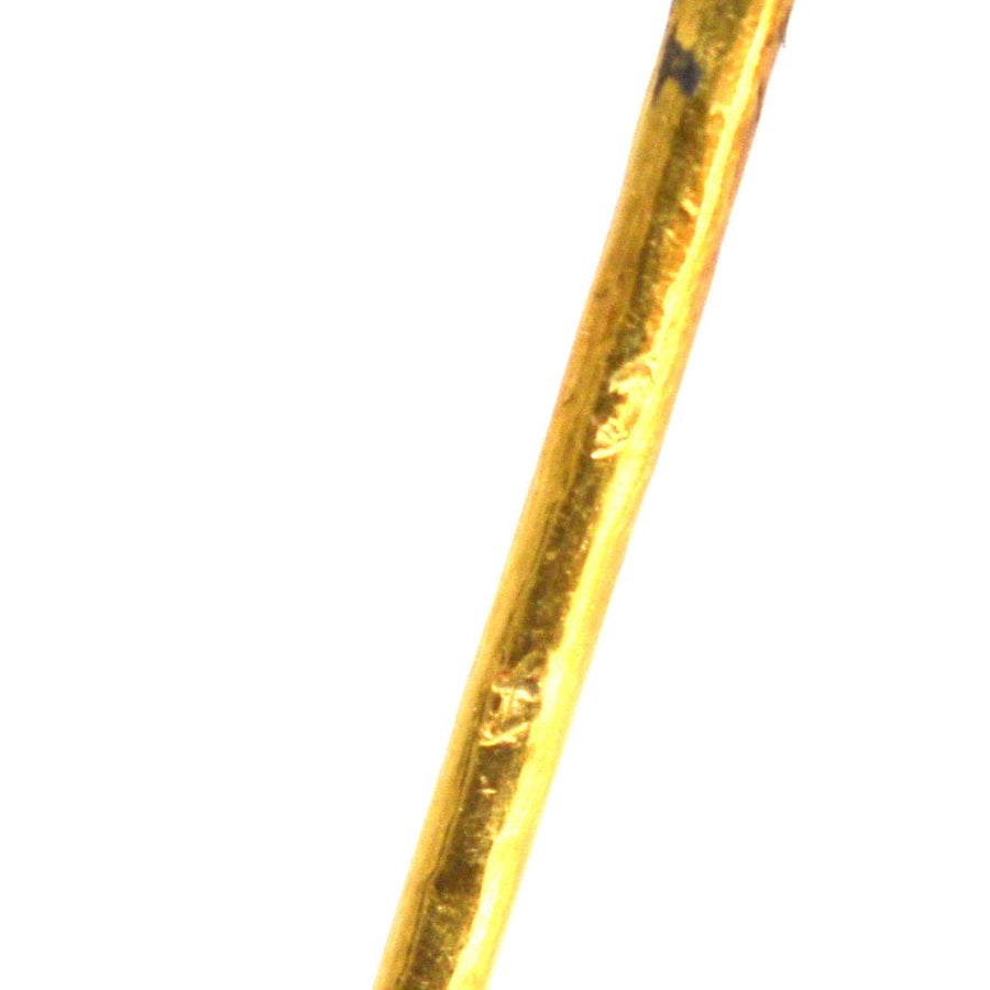 Detailed close-up of a 15ct gold tie pin showcasing a shiny gold finish and subtle imperfections.