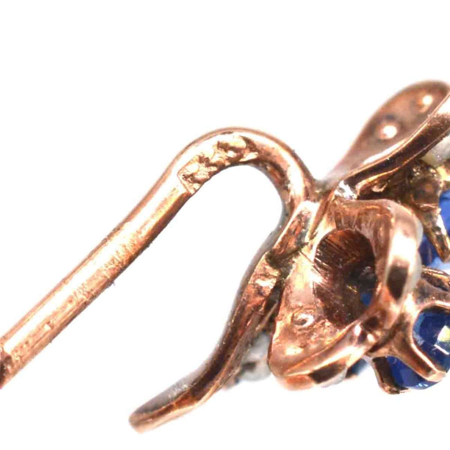 Close-up of early 20th century gold tie pin with sapphire and seed pearl details.