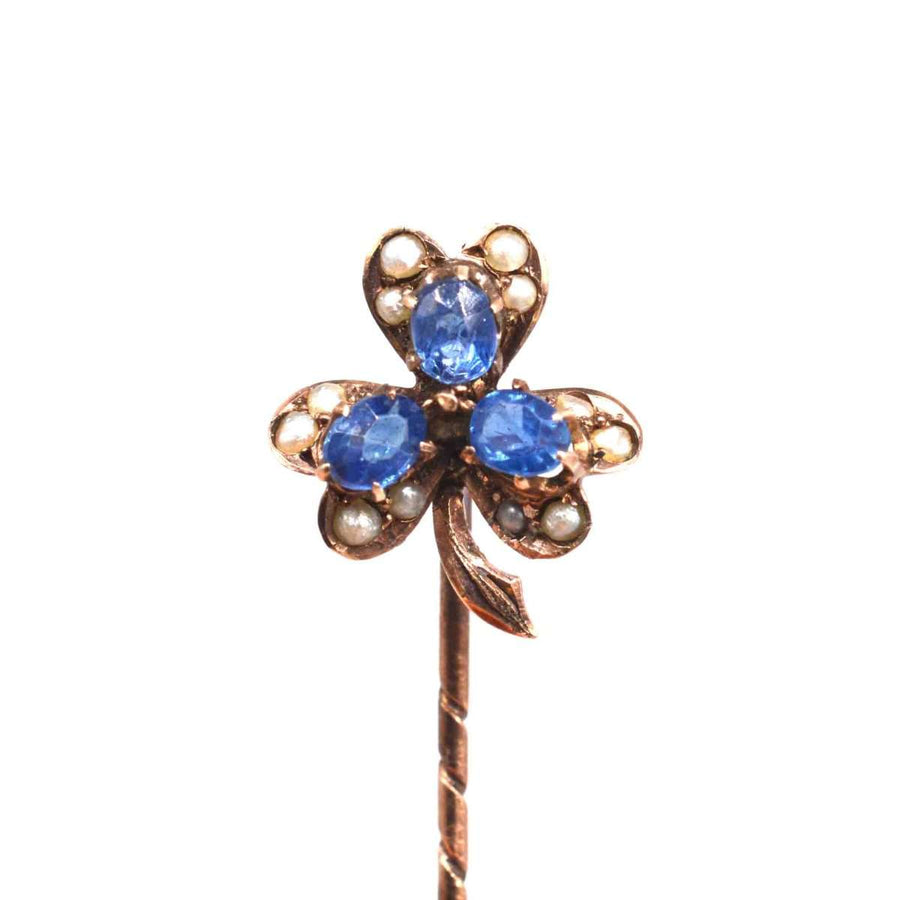 Early 20th century 8ct gold tie pin featuring blue sapphires and seed pearls in a clover design.