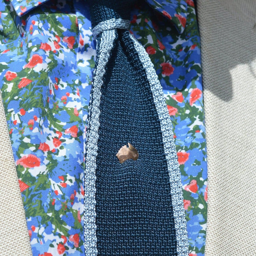 9ct gold tie pin representing Australia, showcased on a floral shirt and stylish tie, perfect as a unique accessory.