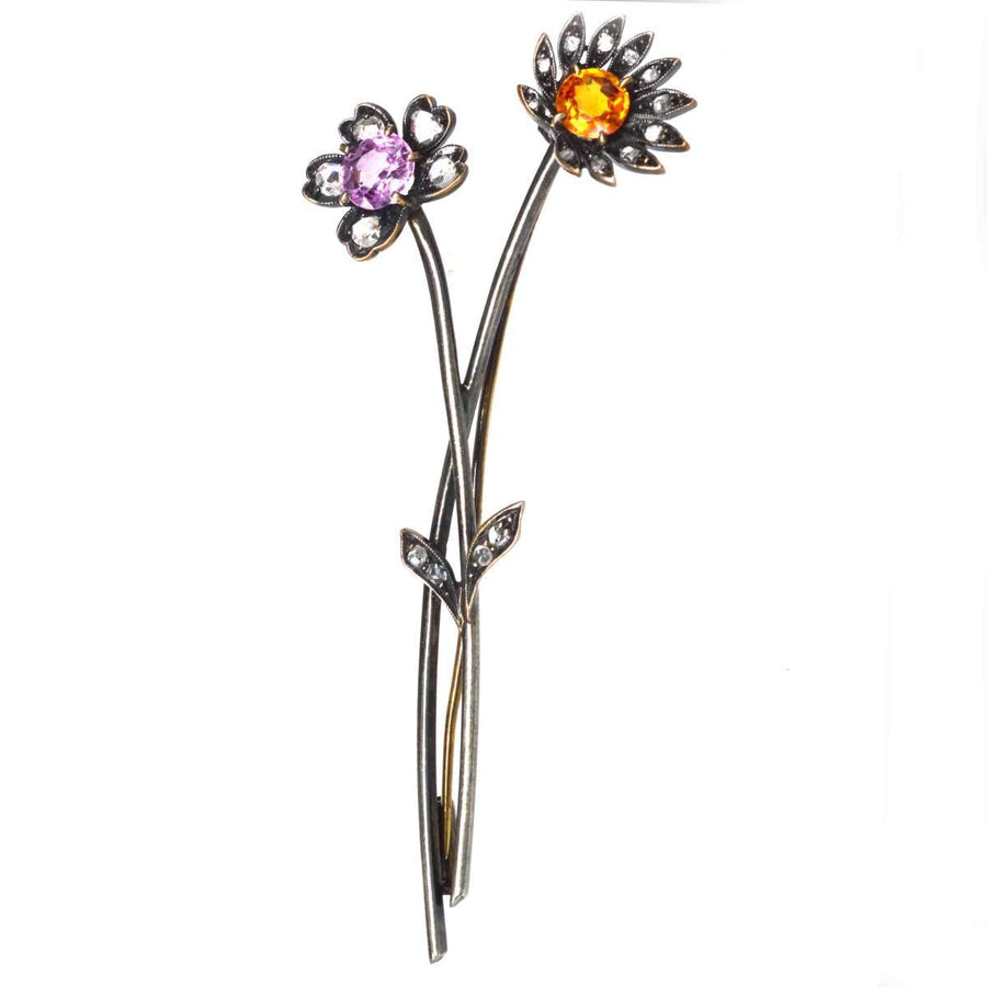 Early 20th century floral brooch in 14ct gold with topaz and diamond accents, showcasing intricate design.