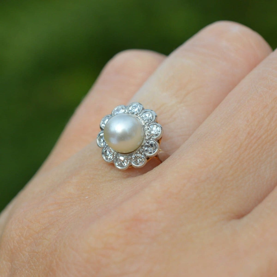 Early 20th century French 18ct gold pearl and diamond cluster ring on hand, showcasing classic elegance.