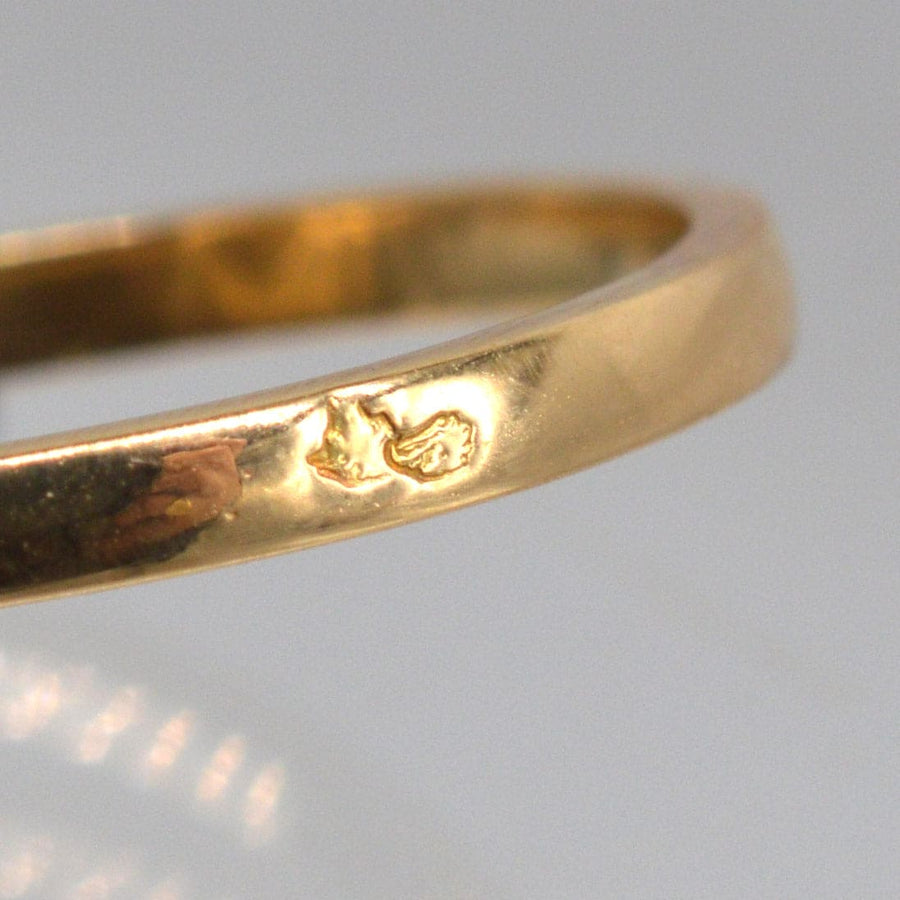 Close-up of a polished 18ct gold ring, showcasing a hallmark and smooth finish.