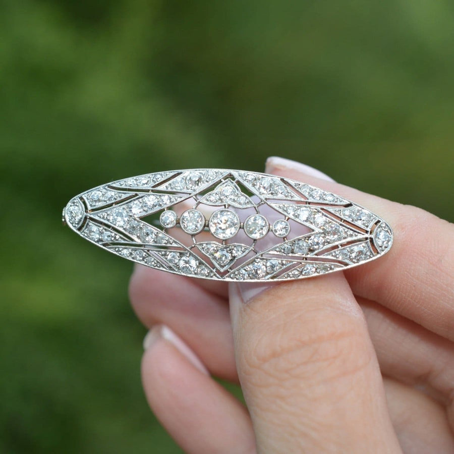 Early 20th century French platinum and gold diamond brooch with geometric design, showcasing sparkling diamonds.