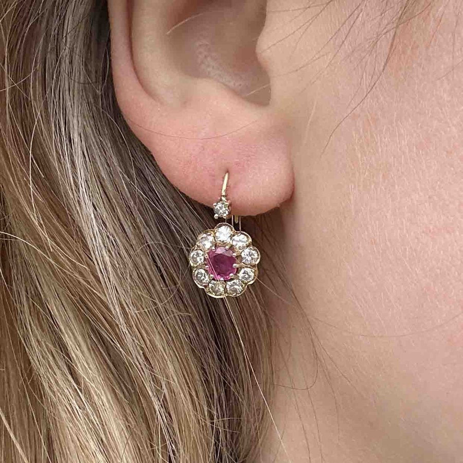 Edwardian 15ct gold diamond and ruby cluster earrings showcased on a model's ear, highlighting their vintage elegance.