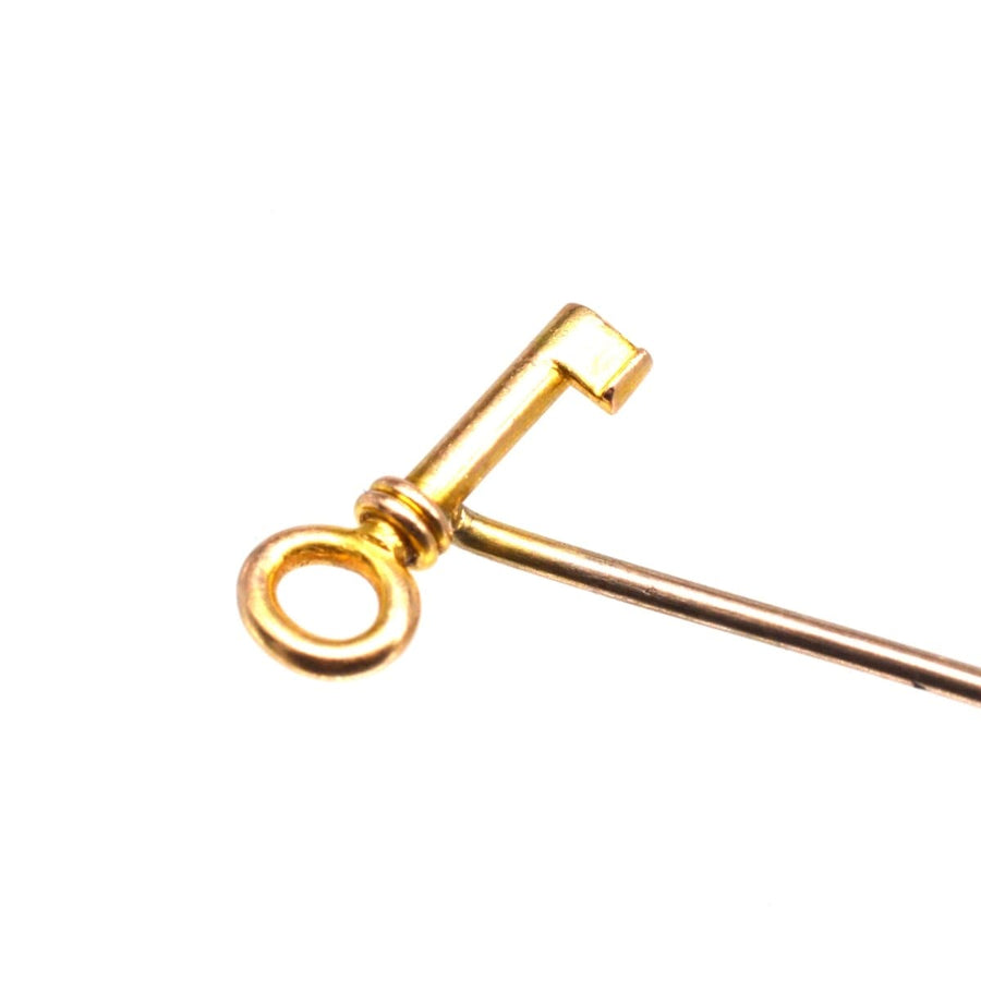 Close-up of an Edwardian 15ct gold tie pin shaped like a key, a symbolic gift for love and success.
